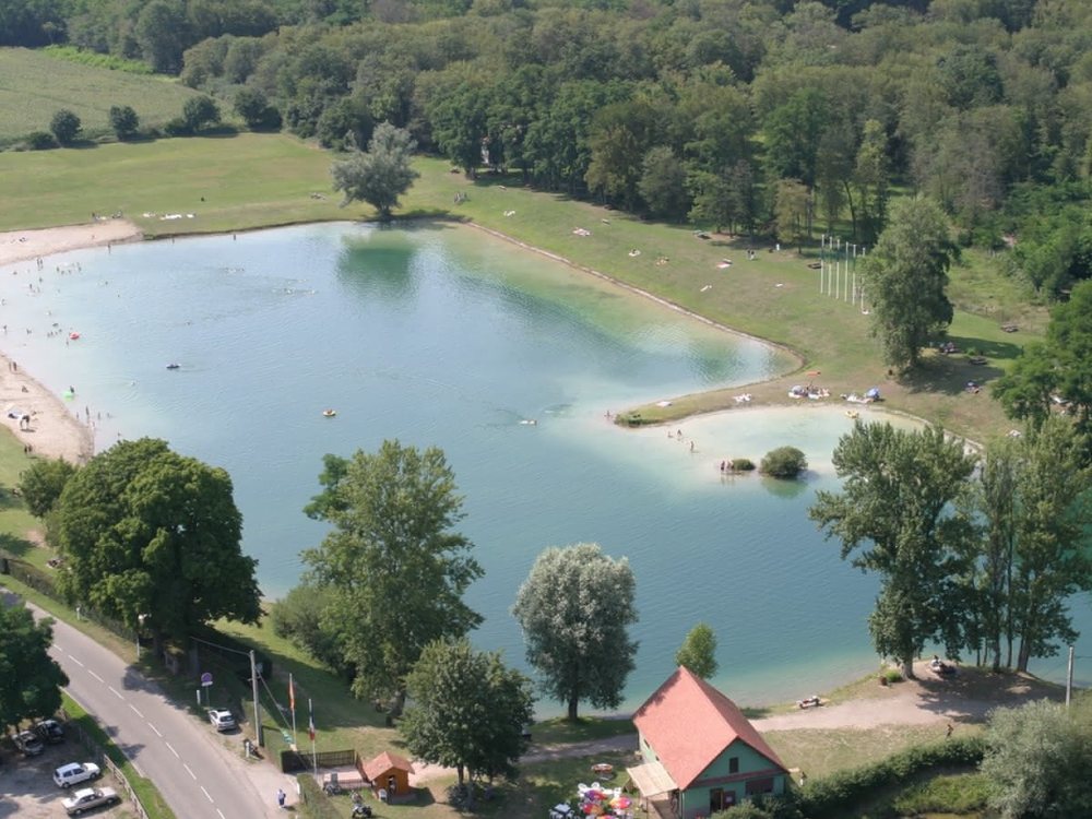 Vue aérienne du plan d’eau du Koba, plage de sable et baigneurs